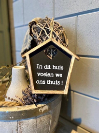 afbeelding klein huisje met de tekst in dit huis voelen we ons thuis