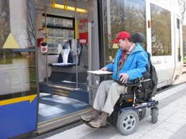 afbeelding man in electrische rolstoel gaat de tram in